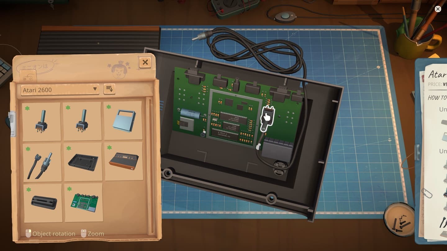 A black console body with a green circuit board, a parts tray, and a panel labeled Atari 2600 sits on a blue repair mat.